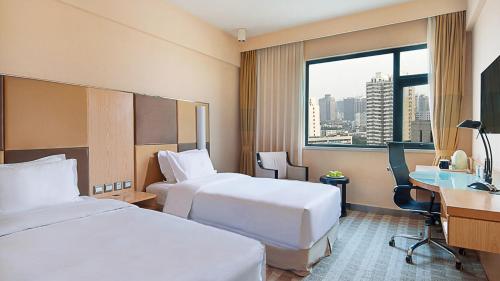 Un pat sau paturi într-o cameră la Holiday Inn Express Zhengzhou Zhongzhou, an IHG Hotel