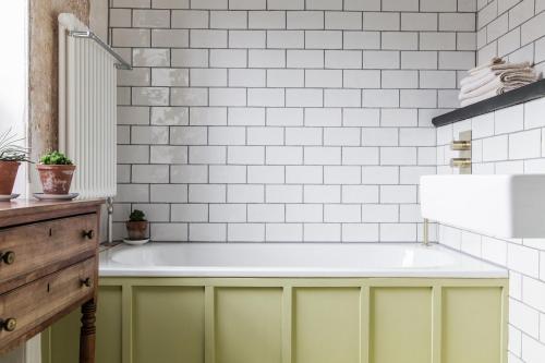 a bathroom with yellow cabinets and white subway tiles at The Bull Inn in Totnes