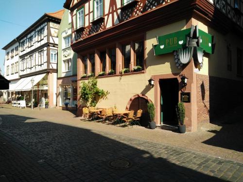 a building with tables and chairs on a street at PUB 111 - Die Altstadt Unterkunft in Miltenberg