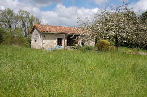 an old stone house in the middle of a field at Studio Gîte de Fontclairet in Champagne-Mouton