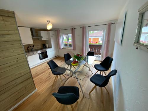 a living room with chairs and a table and a kitchen at Ferienwohnung Dolomiten in Nußdorf