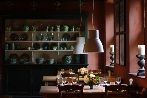 een eetkamer met een tafel met stoelen en glazen bij B&B Kasteelhoeve de Kerckhem in Wijer