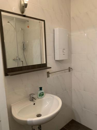 bagno bianco con lavandino e specchio di Renoviert, modern und ruhig a Norimberga