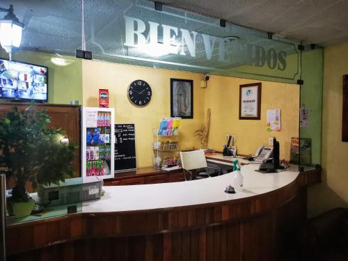 a bar in a restaurant with a clock on the wall at Casa Real in Poza Rica de Hidalgo