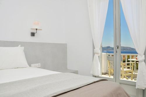 a bedroom with a bed and a view of the ocean at Petros Rooms in Koufonisia