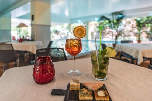 einen Tisch mit zwei Gläsern und einem Teller mit Essen in der Unterkunft Admiral Hotel Villa Erme in Desenzano del Garda