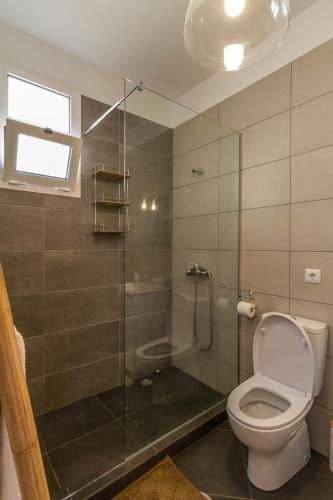 a bathroom with a toilet and a glass shower at maktub sunset property in Paul do Mar