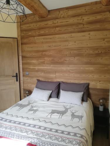 a bedroom with a bed with a wooden wall at Maison de l'Epine -spa- Versant du soleil in Granier