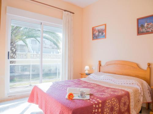 a bedroom with a bed with a table and a window at Apartamentos Canaret Punta Canaret Marineu Playa Romana in Alcossebre
