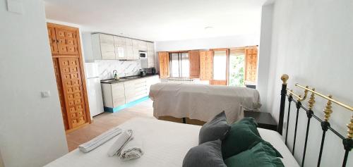 sala de estar con 2 camas y cocina en Apartamentos Casa Botes II, en Cuenca