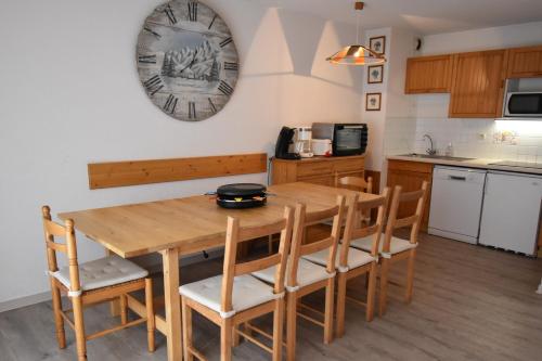 une cuisine avec une table et des chaises en bois dans l'établissement VAUJANYLOCATIONS - Cochette II Apt 15, à Vaujany