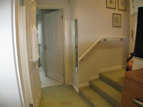 a hallway with a door leading to a stairway at The Lantern in Donaghadee