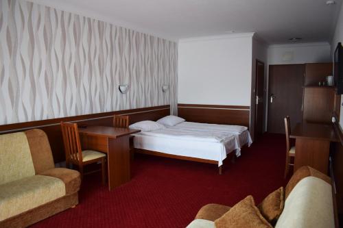 a hotel room with a bed and a desk and chairs at Górska Dolina in Stronie Śląskie