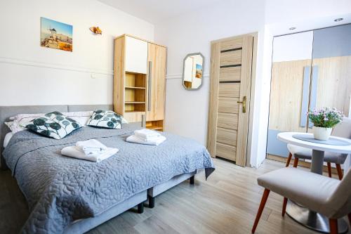 Villa Róża pokoje & apartamenty في ليبا: غرفة نوم بسرير وطاولة وكرسي