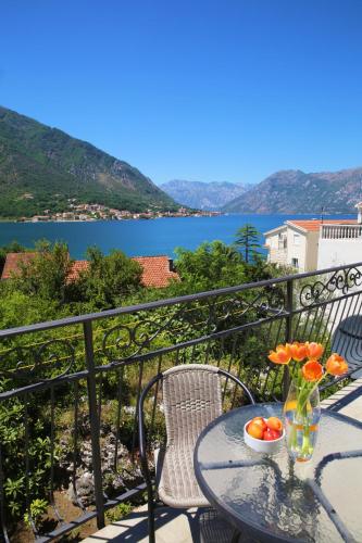 a table and chairs on a balcony with a view of the water at Apartments Jovanovic - Alkima in Kotor