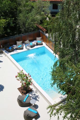 a swimming pool with chaise lounge chairs next to it at Apartments Jovanovic - Alkima in Kotor