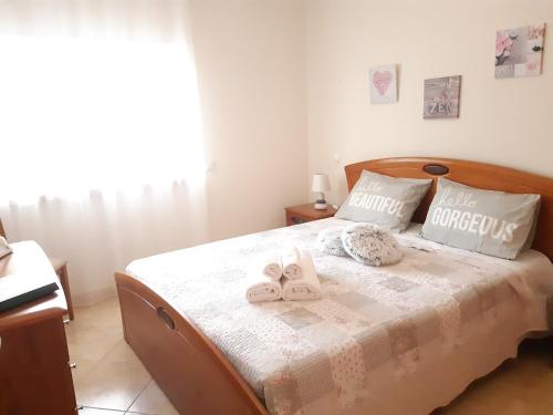 una camera da letto con un letto e asciugamani di ELEGANZ HOUSE a Portimão