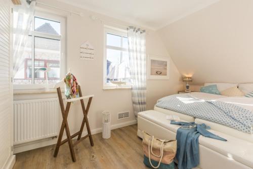 a small bedroom with a bed and a window at Sanddollar in Zingst