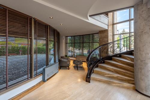 a staircase in a house with large windows at Hotel VEGA Sofia in Sofia