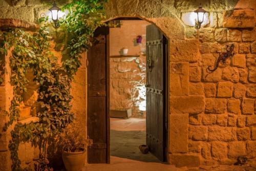 einen Eingang zu einem Steingebäude mit offener Tür in der Unterkunft Dere Suites Cappadocia in Ürgüp