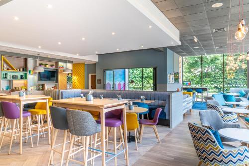 a restaurant with tables and chairs in a cafeteria at Holiday Inn Bournemouth, an IHG Hotel in Bournemouth