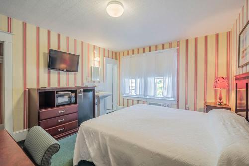 a bedroom with a bed and a tv on the wall at Atlantic Hotel, Inc in Ocean City