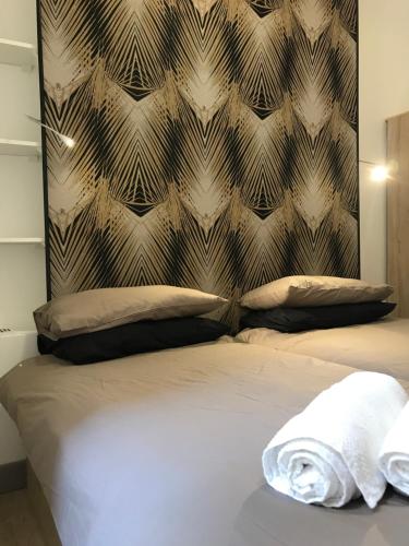 - un lit avec 2 oreillers et un mur dans l'établissement Appartement Suquet Forville, à Cannes