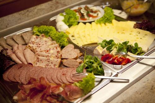 a tray of food with meat and cheese and vegetables at Landgasthof - Hotel zum Stern in Linden