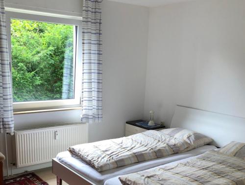 um quarto com 2 camas em frente a uma janela em Ferienwohnung Sommerfeld em Bad Sassendorf