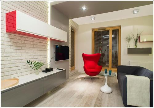 a living room with a red chair and a couch at InPoint Central Apartments in Kraków