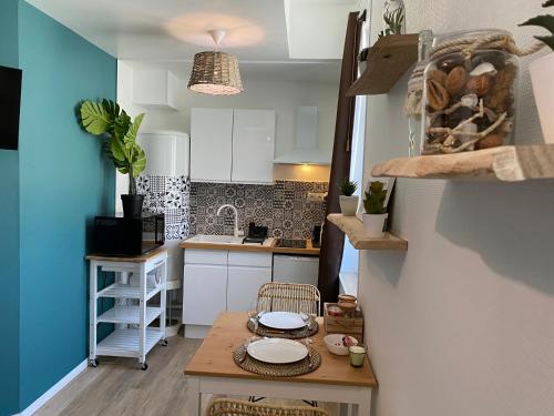 - une petite cuisine avec une table et des plaques de cuisson dans l'établissement La cabane voyage, à Rouen