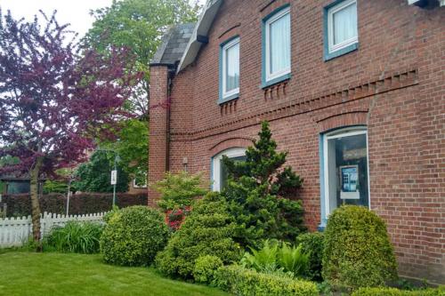 una casa di mattoni rossi con cespugli di fronte di Grosses und gemütliches Landhaus a Sankt Margarethen