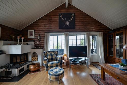 a living room with a fireplace and a tv at Fidjeland 61 in Tjørhom