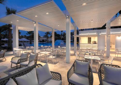 a patio with tables and chairs and a pool at Occidental Sousse Marhaba in Sousse