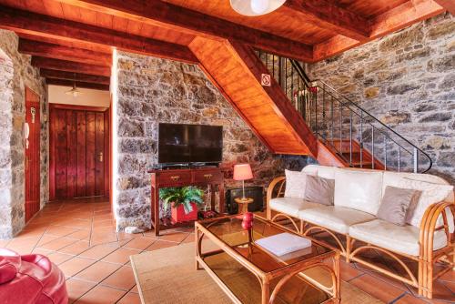 a living room with a couch and a tv at Seixal Sunny Villa A & B by Amazing Madeira in Seixal