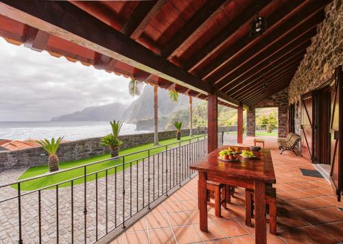 a patio with a table and a view of the ocean at Seixal Sunny Villa A & B by Amazing Madeira in Seixal