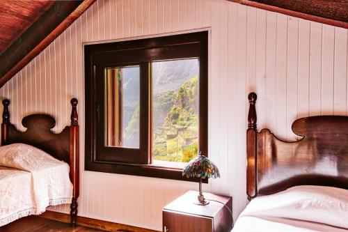 a bedroom with two beds and a window at Seixal Sunny Villa A & B by Amazing Madeira in Seixal