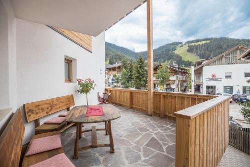 a balcony with a table and a view of a mountain at App Piz de Plaies -ciasa Lavarella in San Vigilio Di Marebbe