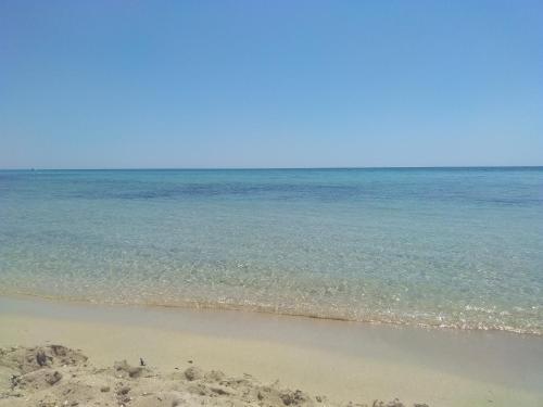 a sandy beach with the ocean in the background at Il sole in Maruggio