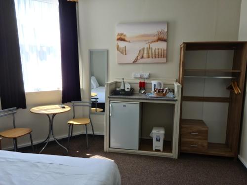 a hotel room with a bed and a table and chairs at Royal Albion Walton in Walton-on-the-Naze