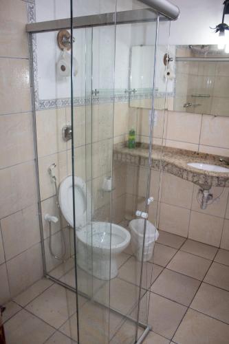 a bathroom with a glass shower with a toilet and a sink at Pousada Estação do Trem in São João del Rei