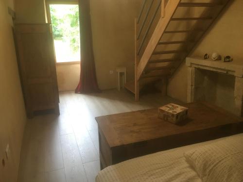 a living room with a staircase and a fireplace at L EntreDeux in Saint-Viaud