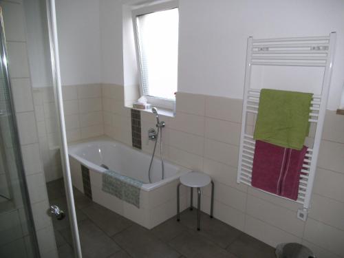 a bathroom with a tub and a window and a stool at Ferienhaus Kettler II in Muhr amSee