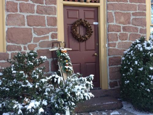 Una puerta púrpura con una corona de Navidad. en Brownstone Colonial Inn, en Reinholds