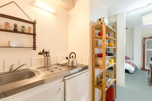 - une cuisine avec un évier et une étagère dans l'établissement Travel Homes -The Cigogne, quiet & heart of Colmar, à Colmar