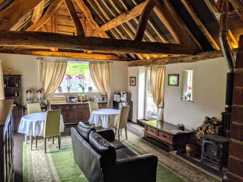 uma sala de estar com sofás e mesas e uma cozinha em Worralls Grove Guest Farm House em Bewdley