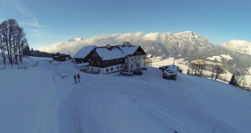 a house in the snow in front of a mountain at Rainzhof in Aich