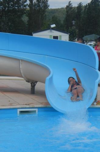 a woman is going down a water slide in a pool at Les sables du midi in Valras-Plage