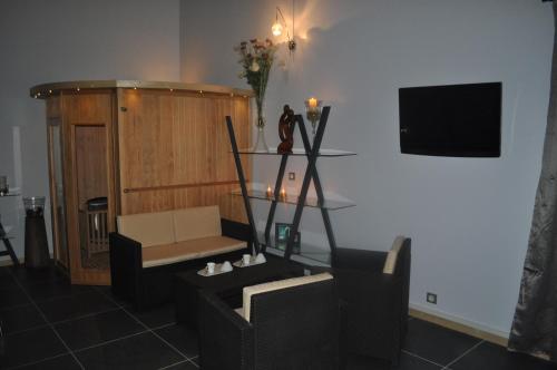 a living room with a couch and a television at La villa des délices in Saint-Privat-des-Vieux