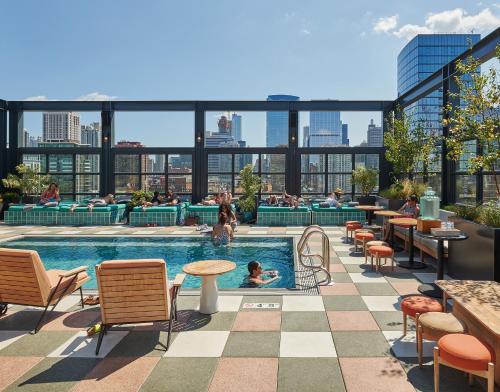 een zwembad op het dak van een gebouw waar mensen zwemmen bij The Hoxton, Chicago in Chicago